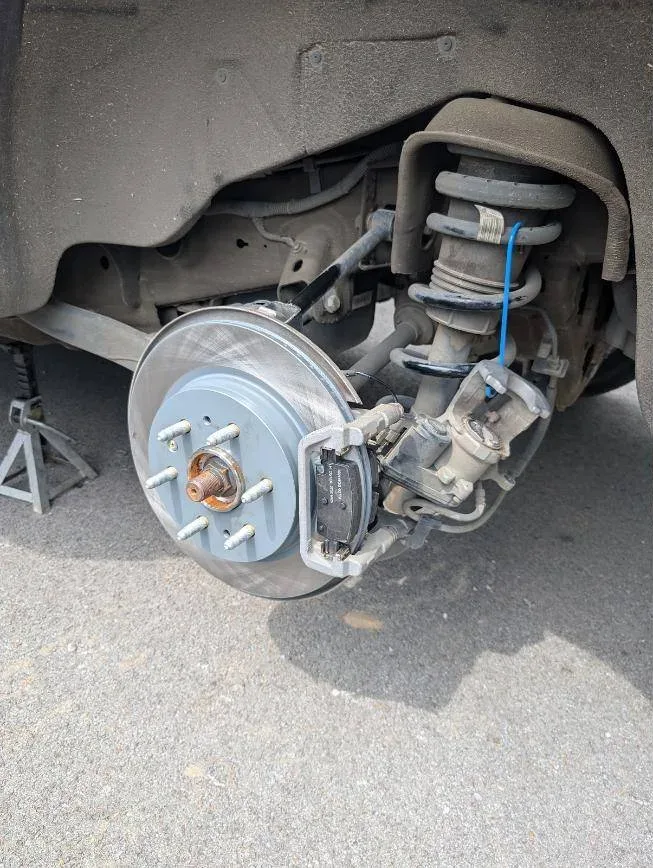 New rotor and brake pads installed on a front wheel hub