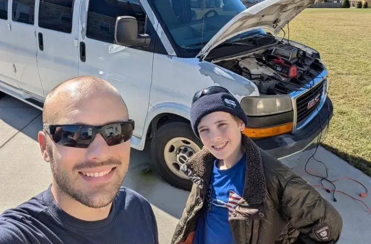 Ed and his son Zack in front of a van with the hood up