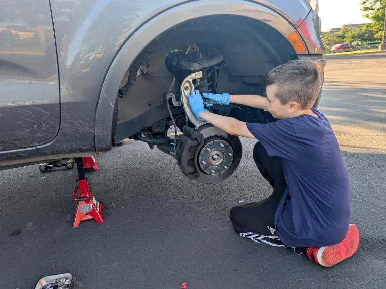 Zack working on a front brake assembly with the wheel off